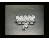 Dent Lab Hail Stone 13mm clear PDR glue tabs, 10-pack on black surface with one tab on its side.
